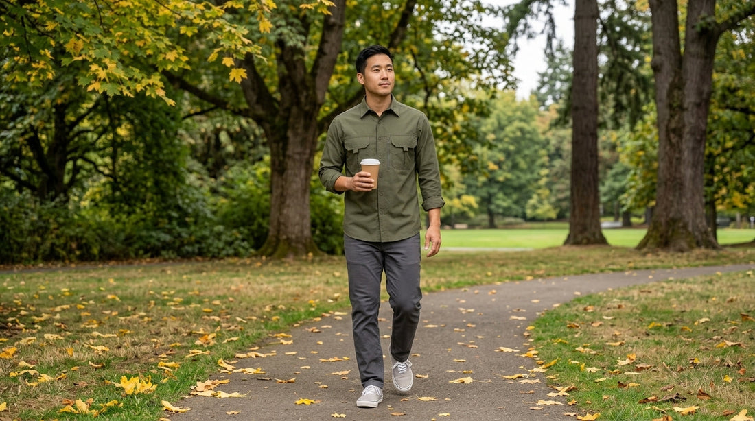 Man wearing an army green utility work shirt untucked with charcoal pants in a Portland park, everyday gorpcore style