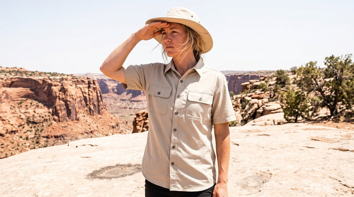 Hiker in a light sand-colored quick-dry shirt on sunlit slickrock in southern Utah at midday