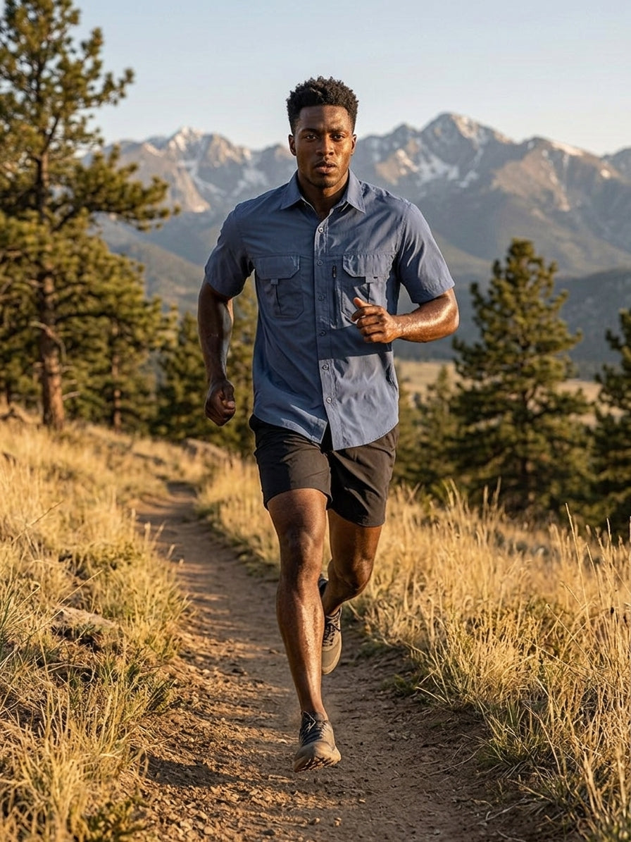 Trail runner in a quick-dry short-sleeve shirt running downhill on singletrack in the Colorado Front Range at sunrise
