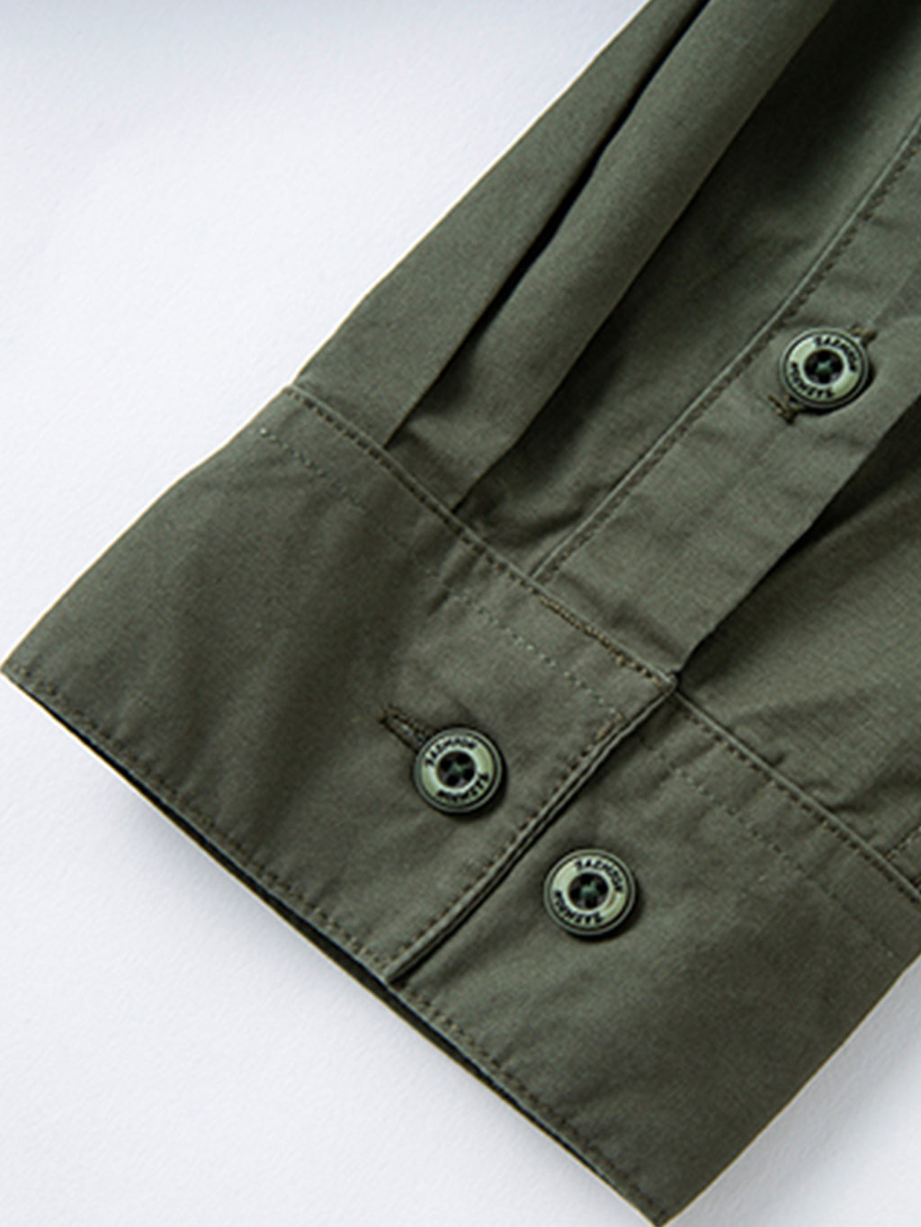 Green buttoned jacket sleeve, durable high-performance outdoor apparel by FREDD MARSHALL