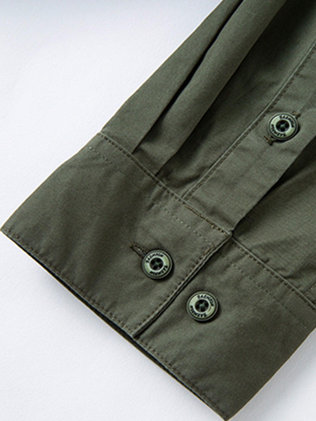 Green buttoned jacket sleeve, durable high-performance outdoor apparel by FREDD MARSHALL