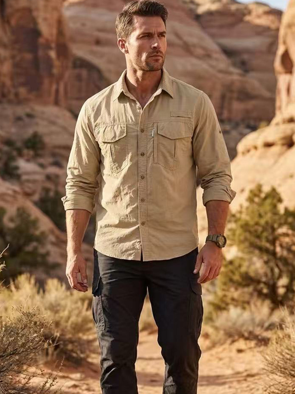 Man wearing high-performance outdoor apparel, beige shirt, black pants, hiking in desert landscape