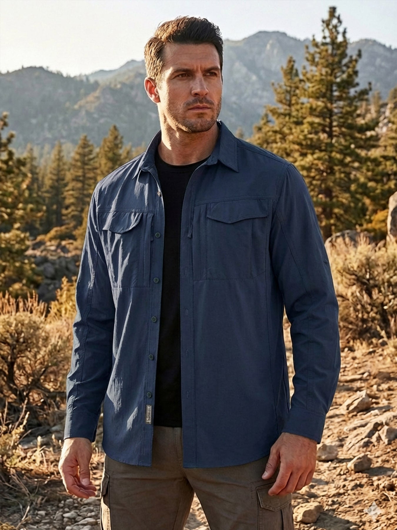 Man wearing high-performance outdoor apparel by FREDD MARSHALL in a rugged mountain setting