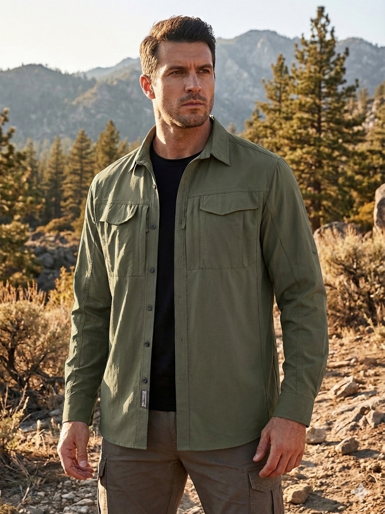 Man wearing high-performance outdoor apparel shirt in green, standing in a mountain forest