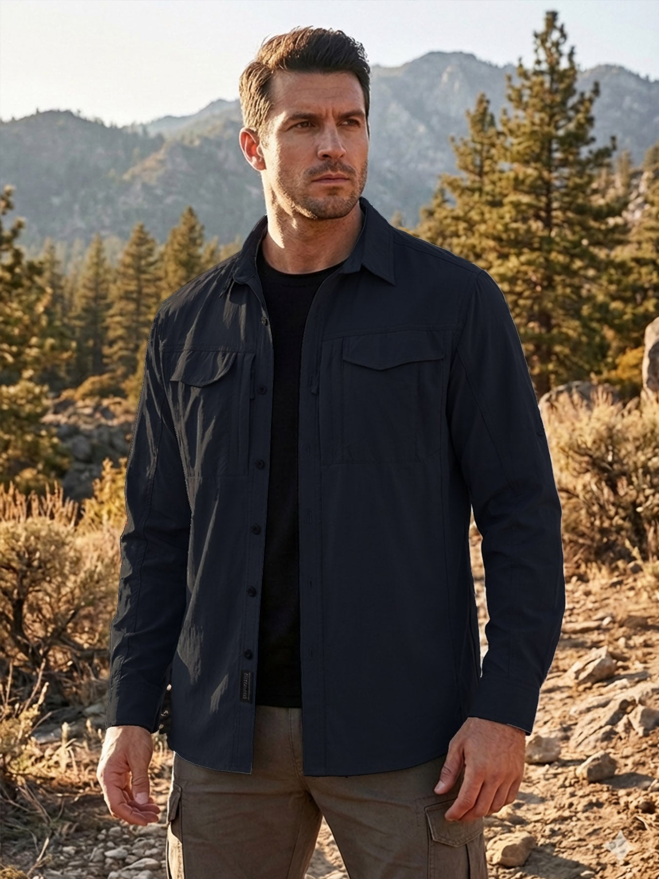 Man wearing high-performance outdoor apparel shirt in a rugged forest mountain setting