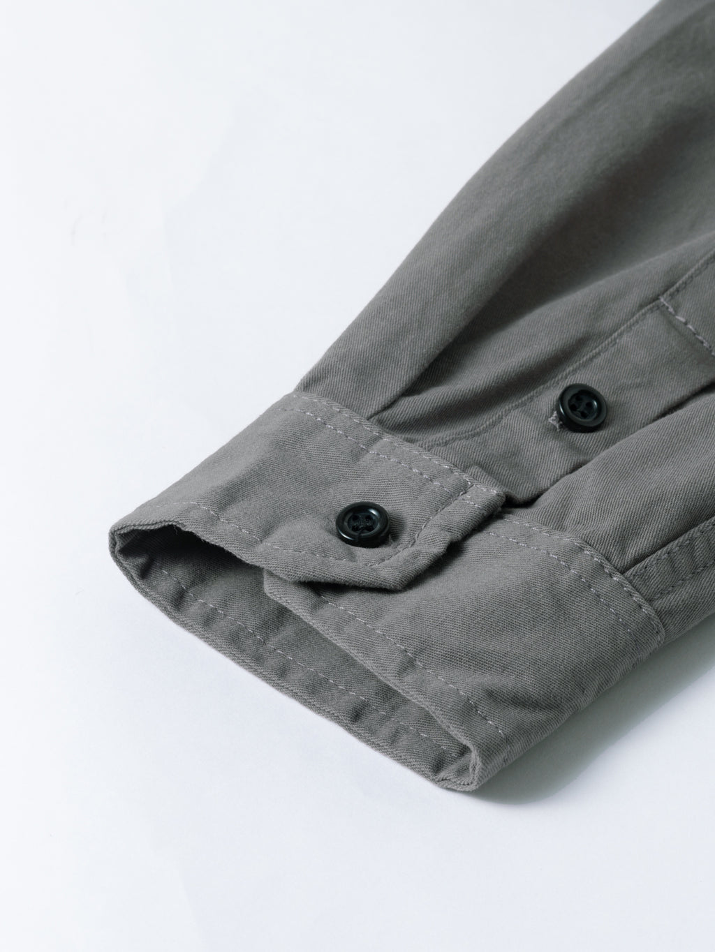 Close-up of grey high-performance outdoor shirt cuff with black buttons by FREDD MARSHALL